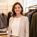 Lesa Pfeifer, lead stylist, standing in a bright Cardiff luxury boutique beside tailored clothing